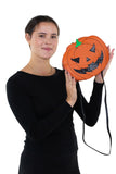 Sleepyville Critters - Pumpkin Two Faced Jack O Lantern Crossbody Bag in Vinyl Material, no glitter side, handheld by model