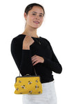 Bees Kisslock Bag inYellow Cotton, side view handheld style on model